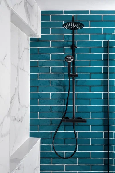 Aguamarina oscura y blanca y color en el baño. Moderna ducha de azulejos con cabeza de lluvia, ducha de mano. —  Fotos de Stock