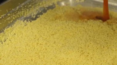 Metal tepside kuskus suyuna sıcak et suyu katıyorum. Ticari mutfakta yemek pişirmek.