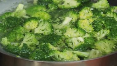 Kaynar suda brokoli parçaları. Mutfakta sebzeleri sağlıklı yemek için pişiriyorum..