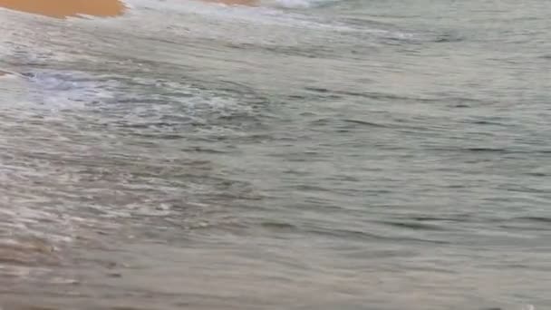 Közelkép gyönyörű azúrhullámok címereiről. Természetes tengeri háttér türkiz hullámok lassan gördül át a homokos parton a strand.