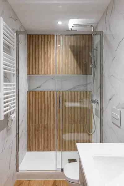 Duschbereich mit Holzverarbeitung und Glastür. Interieur des modern renovierten Badezimmers — Stockfoto