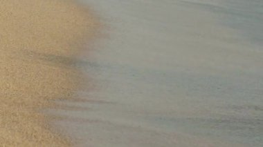 Akdeniz dalgaları kumsala doğru yuvarlanıyor. Güneşin doğuşunda dingin köpüklü su