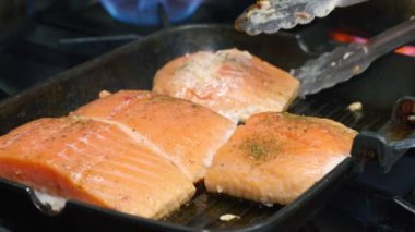 Mutfakta balık ızgara tavasında kızartma işlemi. Izgara somon bifteği yakın plan.