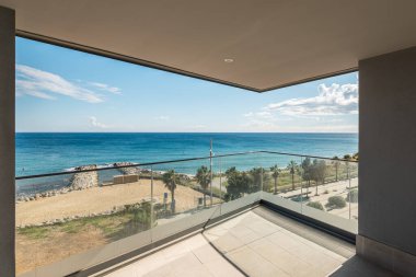 Barcelona 'daki Akdeniz manzaralı modern bir balkon manzarası. Sahnede kumlu sahil, palmiye ağaçları ve açık mavi gökyüzü var..