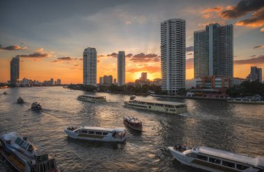 Yoğun Chao Phraya Nehri Yolcu Gemileri ve Gökdelenleri Sunset 'te Tayland, Bangkok' taki Taksin Köprüsü 'nden