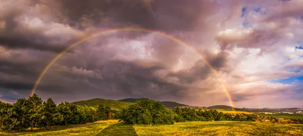 Rainbow over landschap bij zonsondergang — Stockfoto