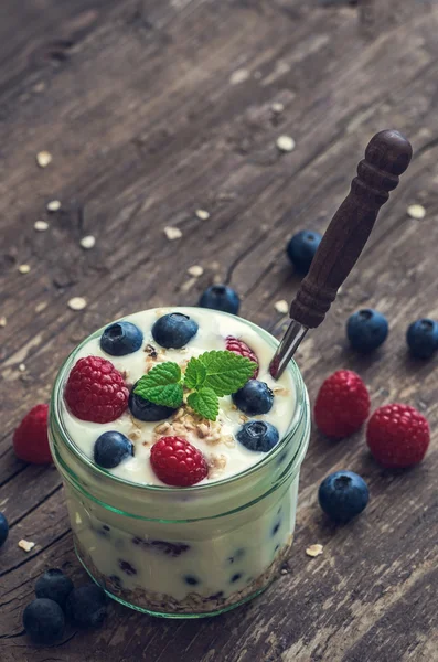 Joghurt mit frischen Beeren auf Holztisch — Stockfoto