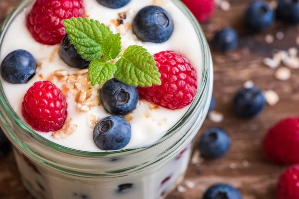 Joghurt mit frischen Beeren auf Holztisch — Stockfoto