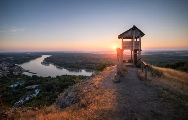 Trä turist observationen står hög ovanför en liten stad med floden — Stockfoto