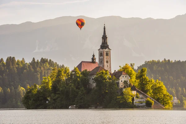 Katholische Kirche im slowenischen See mit Heißluftballonflug — Stockfoto