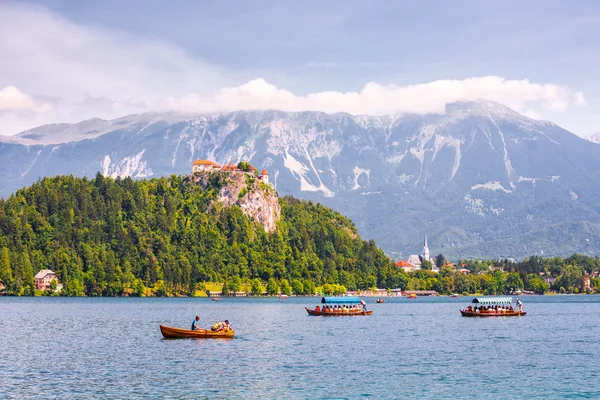 Ausgeblutete Burg am Abgrund mit Blick auf den See mit Touristen und Booten — Stockfoto