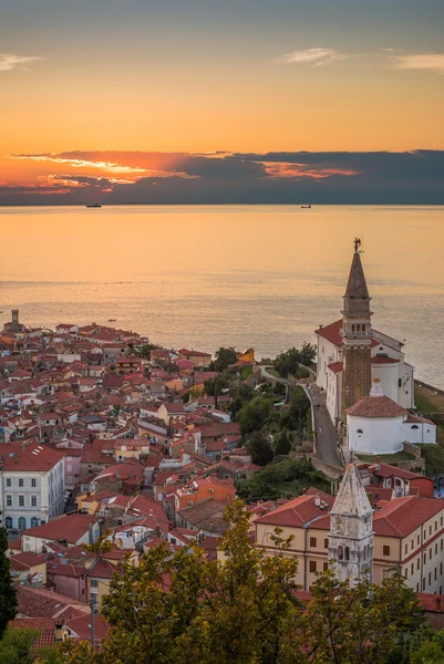 Auringonlasku Adrianmeren yllä ja Piranin vanhakaupunki, Slovenia — kuvapankkivalokuva