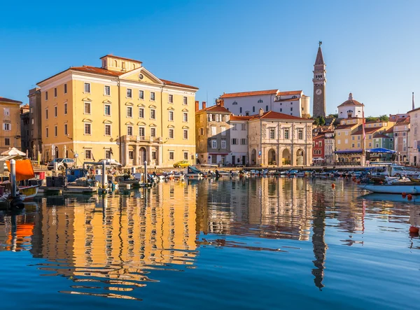 Tükröződik a víz Piran óvárosának épületei. — Stock Fotó