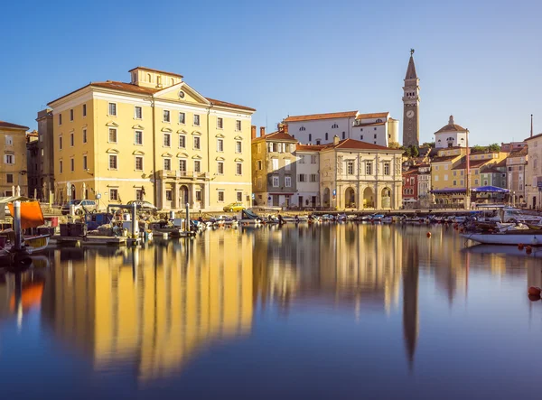 Tükröződik a víz Piran óvárosának épületei. — Stock Fotó