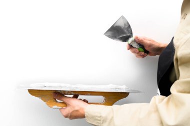 Bir spatula ile el, macun katmanı uygulama süreci. Dairelerin tadilatı. Duvarları onar. Reklam ve metin için boş alan.