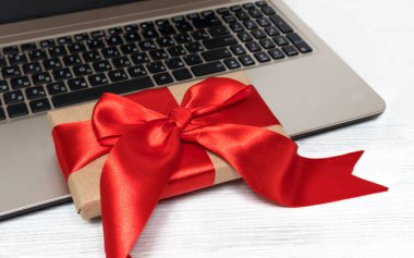 Laptoplu masa ve hediye kutusu masada, arka planda. Alışveriş aletleri mağazası web sitesi indirimleri ve hediyeler. Kara Cuma ve siber pazartesi en iyi satın alma konseptini sunar.