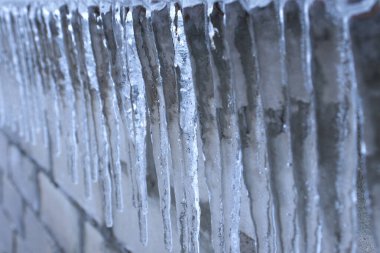 Evin penceresinden sarkan buz sarkıtları. Kötü soğuk hava kavramı, dondurucu soğuk. iklim, don, donma.