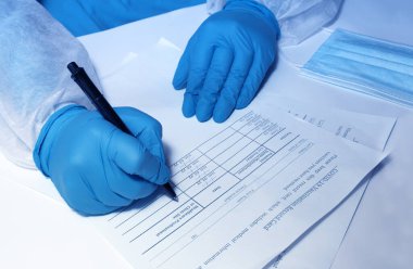 Doktorun elleri yakın plan, Aşı Kayıt Kartı 'ndaki verileri kaydediyor. Sağlık ve tıp teknolojisi