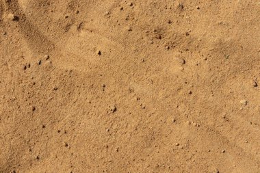 Kumsalda kum, yakın çekim. Sarı inşaat kumu, yüzey dokusu, inşaat çimentosu