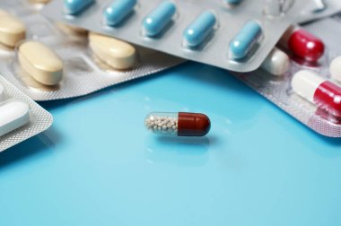 Açık mavi tıbbi yansıtıcı arka planda haplar, haplar ya da kapsüller. İlaç, sağlık, tedavi, eczane konsepti. Tıbbi geçmiş.
