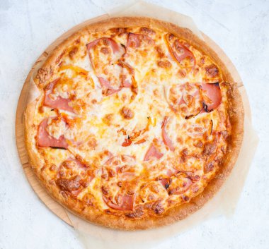 Mozzarella peynirli, jambonlu, domatesli ve soslu pizza.