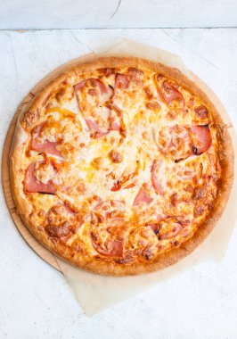 Mozzarella peynirli, jambonlu, domatesli ve soslu pizza.