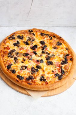 Peynirli, jambonlu, mantarlı, tavuklu ve soslu pizza.