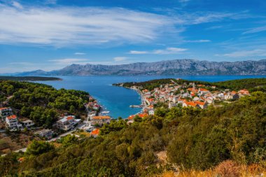 POVLJA, CROATIA - Ağustos 2020: Brac Adası 'ndaki güzel Povlja köyü ve arkaplanı Mosor dağı. Panoramik görünüm.