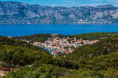 POVLJA, CROATIA - Ağustos 2020: Brac Adası 'ndaki güzel Povlja köyü ve arkaplanı Mosor dağı. Panoramik görünüm.