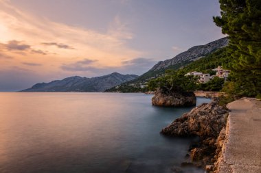 Brela Stone (Kamen Brela) - Hırvatistan 'da popüler bir doğal cazibe olan Brela' nın sembolü. Brela Stone, Punta Rata plajı, Hırvatistan 'ın Makarska Riviera kentinin güzel günbatımı manzarası. Uzun pozlama resmi.