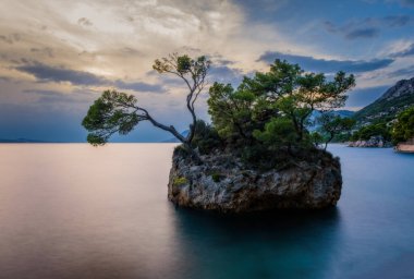 Brela Stone (Kamen Brela) - Hırvatistan 'da popüler bir doğal cazibe olan Brela' nın sembolü. Brela Stone, Punta Rata plajı, Hırvatistan 'ın Makarska Riviera kentinin güzel günbatımı manzarası. Uzun pozlama resmi.