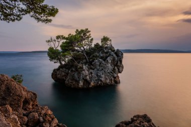 Brela Stone (Kamen Brela) - Hırvatistan 'da popüler bir doğal cazibe olan Brela' nın sembolü. Brela Stone, Punta Rata plajı, Hırvatistan 'ın Makarska Riviera kentinin güzel günbatımı manzarası. Uzun pozlama resmi.