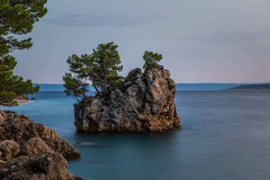 Brela Stone (Kamen Brela) - Hırvatistan 'da popüler bir doğal cazibe olan Brela' nın sembolü. Brela Stone, Punta Rata plajı, Hırvatistan 'ın Makarska Riviera kentinin güzel günbatımı manzarası. Uzun pozlama resmi.