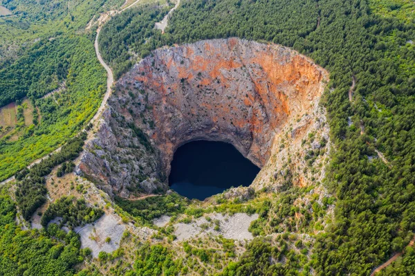 Red Lake (Croatian: Crveno jezero) is a collapse doline (collapse sinkhole) containing a karst lake close to Imotski, Croatia. It is 530 metres deep, thus it is the largest collapse doline in Europe. August 2020, aerial drone shot