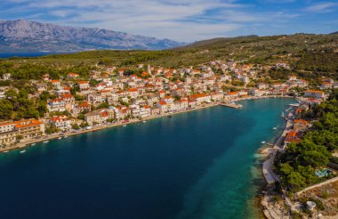 POVLJA, CROATIA - Ağustos 2020: Brac Adası 'ndaki güzel Povlja köyü ve arkaplanı Mosor dağı. Panoramik manzara. Hava aracı görüntüsü.