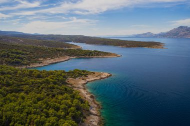 POVLJA, CROATIA - Ağustos 2020: Brac Adası 'ndaki güzel Povlja köyü ve arkaplanı Mosor dağı. Panoramik manzara. Hava aracı görüntüsü.