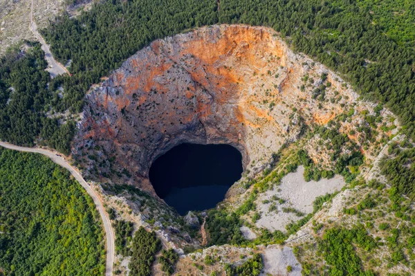 Crveno jezero) - це заглиблена карстова лійка, що містить карстове озеро поблизу Імотського, Хорватія. Глибина 530 метрів, таким чином, це найбільша лялька в Європі. — стокове фото