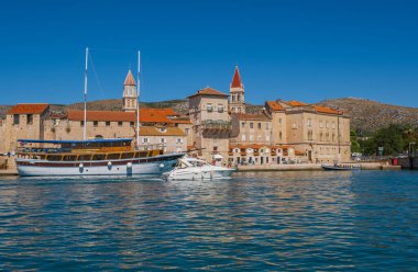 Trogir, Hırvatistan. Hırvatistan 'ın Dalmaçya kıyısındaki eski Venedik kasabasının iskelesi boyunca güneşli bir gezinti. Eylül 2020