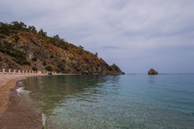 Rixos Hotel tekirova yakınlarında güneş gözlüklü, boş bir sahilden kayaların ve ufkun görüntüsü. Akdeniz 'de. Tekirova, Antalya Türkiye. Mayıs 2021.