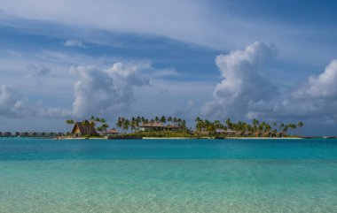 Hard Rock Otel iskelesinin sonunda ve zümrüt suyunun arka planında palmiyeler olan binalar. Maldivler Kavşağı, Temmuz 2021