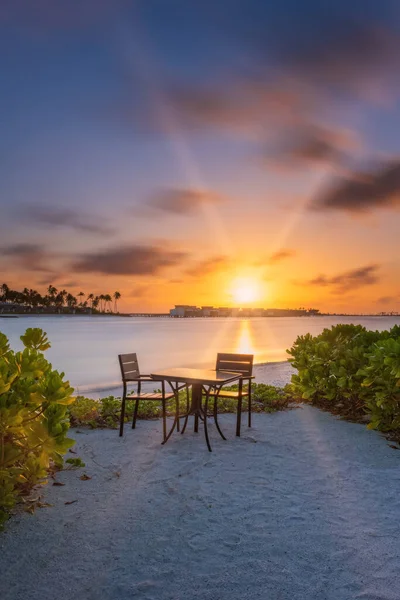 Outdoor restaurant with views of ocean and beautiful sky at sunrise. Crossroads Maldives, saii lagoon. Long exposure picture. July 2021