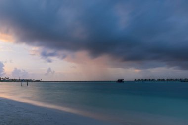 Okyanus dalgalarında gün batımı ışığı parlıyor. Maldivler plajı. Temmuz 2021