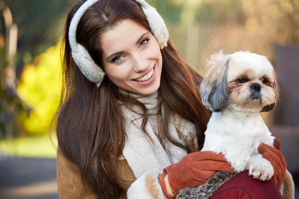 Mujer joven jugando con un perro pequeño — Foto de Stock