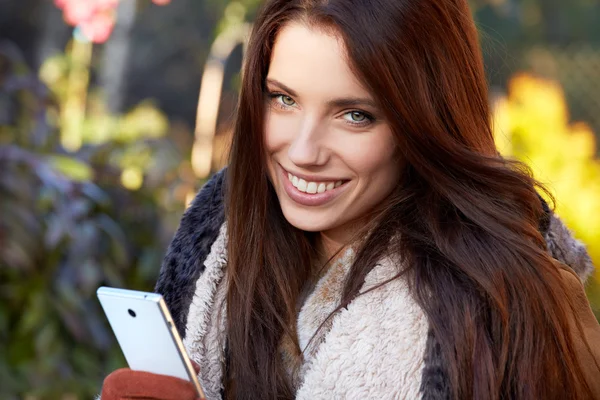 Lovely young woman uses a smartphone — Stock Photo, Image