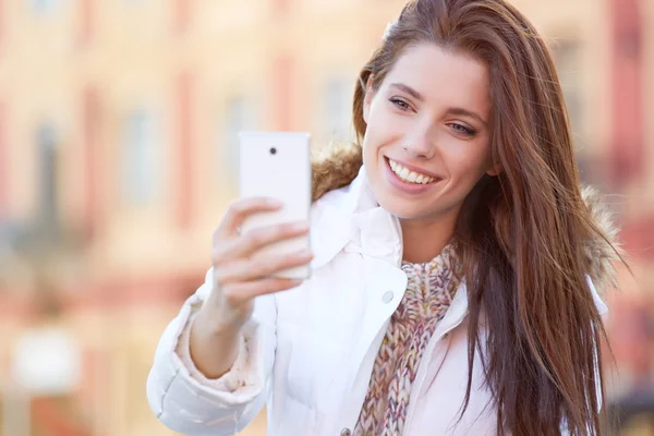 Pretty young woman taking a picture on town — Stock Photo, Image