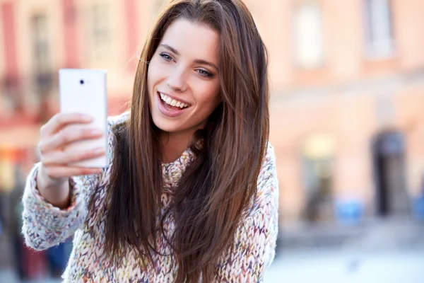 Bonita joven mujer tomando una foto en la ciudad — Foto de Stock