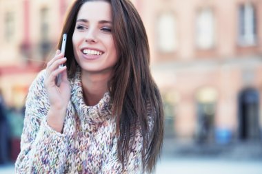 Güzel bir kadın telefonda konuşuyor.