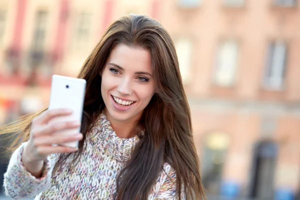 Bonita joven mujer tomando una foto en la ciudad — Foto de Stock