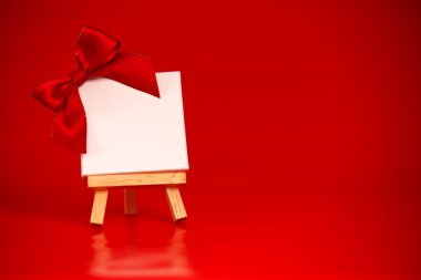 boş tuval üzerinde Noel kırmızı arka plan ile ahşap şövale 