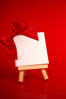 boş tuval üzerinde Noel kırmızı arka plan ile ahşap şövale 